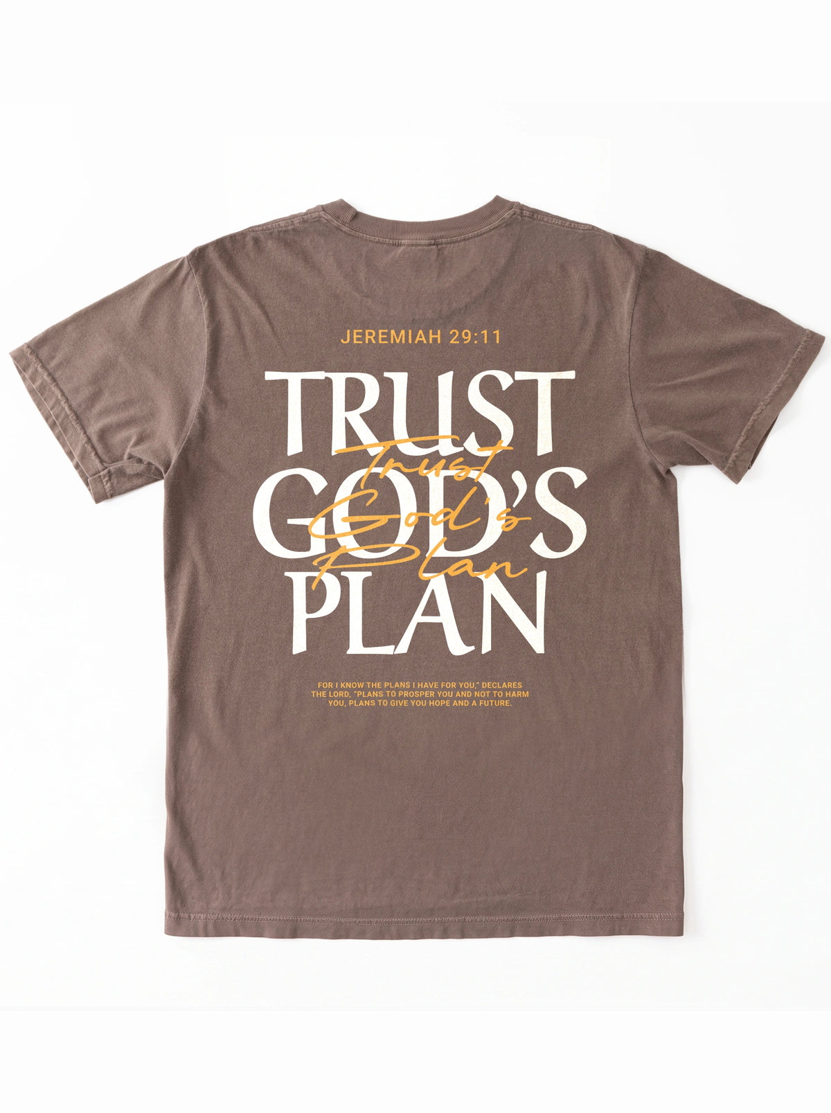 Faded brown T-shirt laid flat with a large back design reading “JEREMIAH 29:11” and “TRUST GOD’S PLAN,” with the verse below.