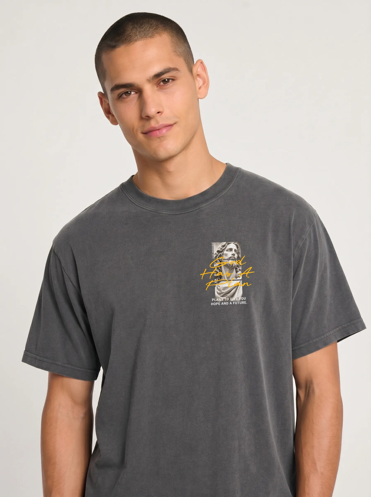 Person wearing a charcoal gray T-shirt with a statue graphic and the text “God Has A Plan” and “Plans to give you hope and a future.”