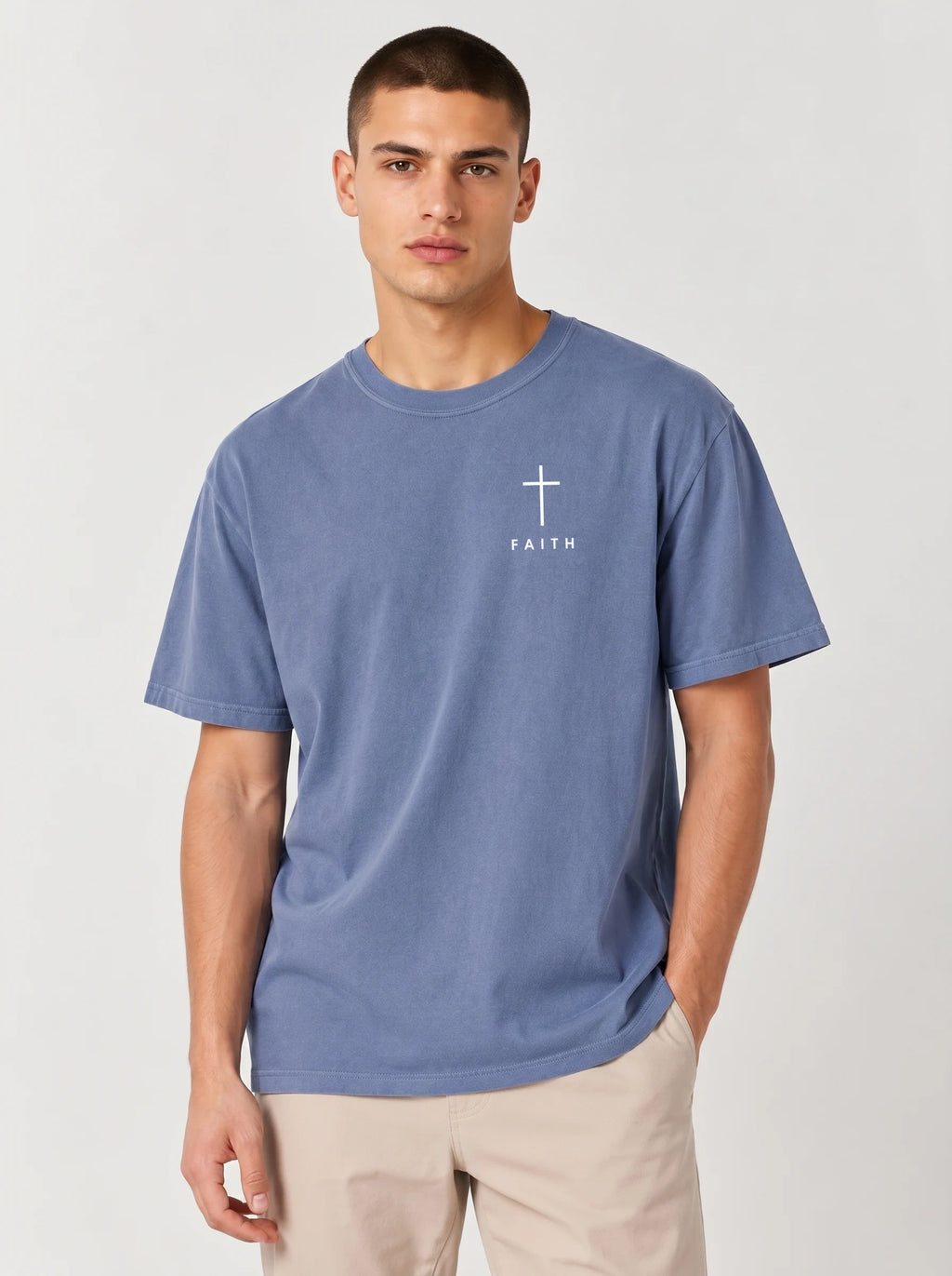 Faded blue T-shirt laid flat with a white cross and “FAITH” printed on the chest.