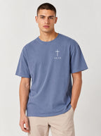 Faded blue T-shirt laid flat with a white cross and “FAITH” printed on the chest.