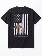 A black short-sleeve t-shirt shown from the back, featuring a distressed white American flag graphic with a brown cross and a gold chain link design in the center, and the text 'FAITH, FAMILY, FREEDOM.' printed below in gold.