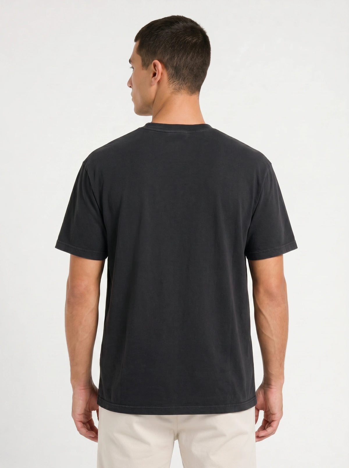 Back view of a person wearing a plain black T-shirt.