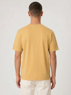 Back view of a person wearing a plain mustard yellow T-shirt.