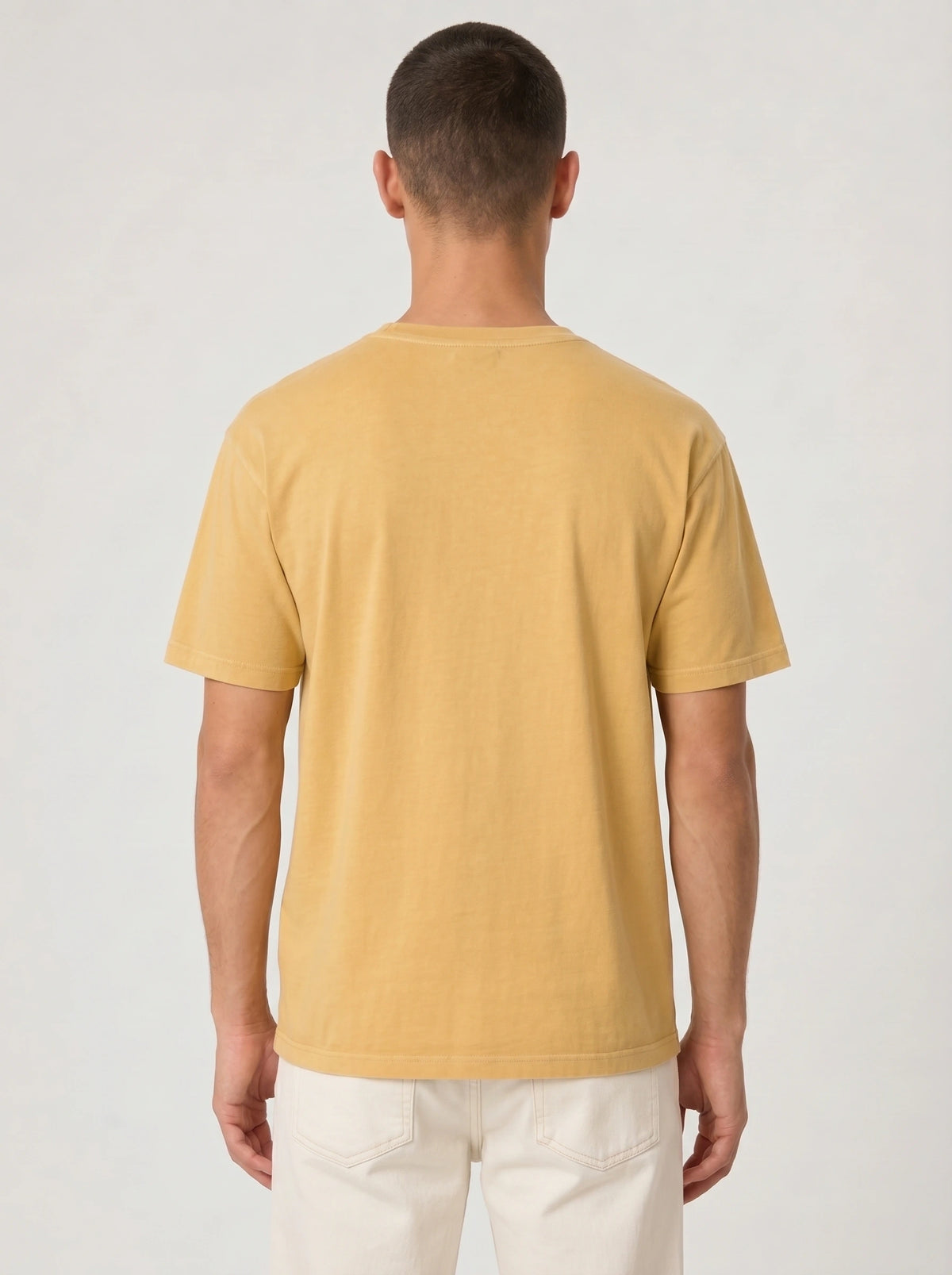 Back view of a person wearing a plain mustard yellow T-shirt.
