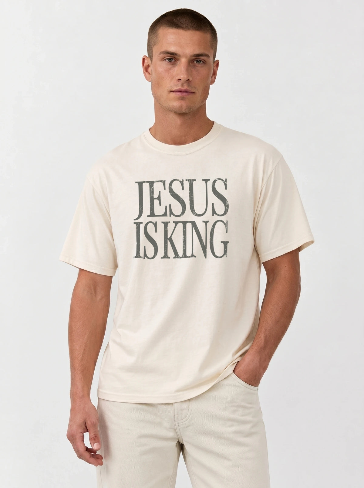 Man wearing an ivory Comfort Colors garment-dyed Jesus Is King t-shirt with a faith-based graphic tee design