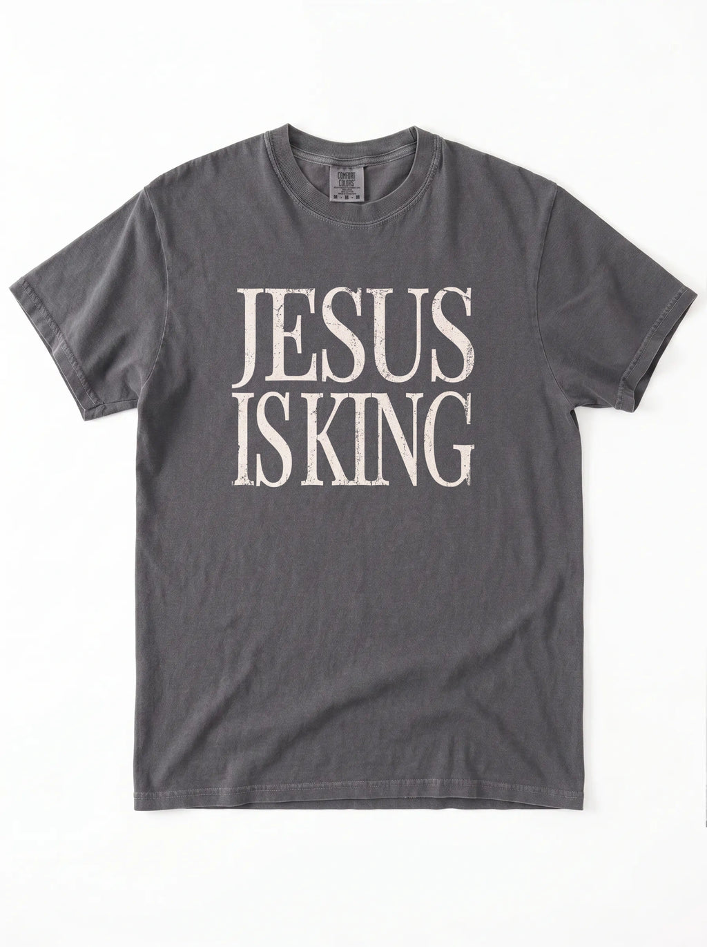 Charcoal gray T-shirt laid flat with distressed cream text reading “Jesus Is King.”
