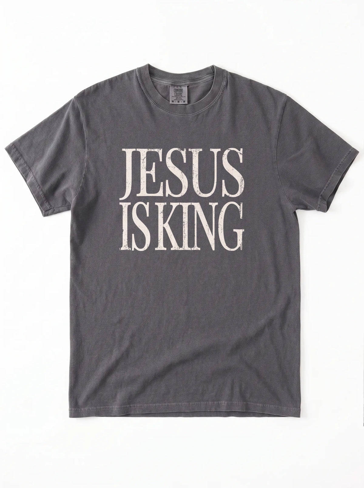 Charcoal gray T-shirt laid flat with distressed cream text reading “Jesus Is King.”