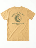 A tan short-sleeve t-shirt shown from the back, featuring a dark olive green graphic of a lion's head with the text 'BLESSED IS THE MAN' and 'WHOSE CONFIDENCE IS IN HIM' with 'jeremiah 17:7' underneath.