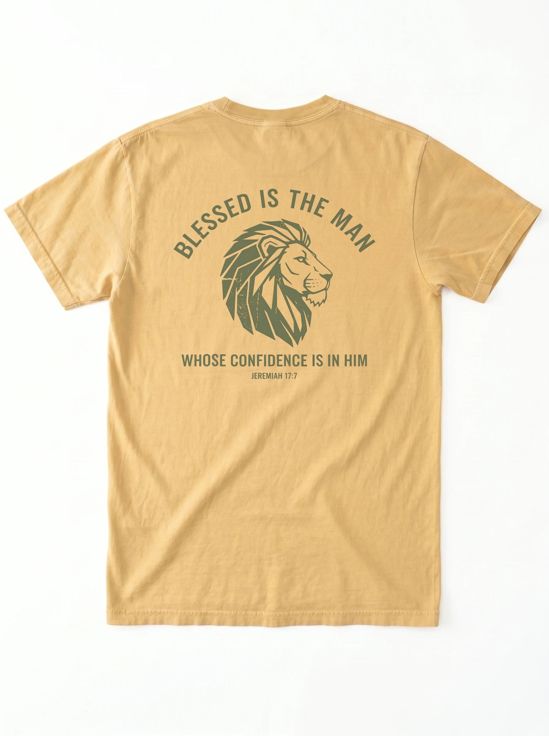A tan short-sleeve t-shirt shown from the back, featuring a dark olive green graphic of a lion's head with the text 'BLESSED IS THE MAN' and 'WHOSE CONFIDENCE IS IN HIM' with 'jeremiah 17:7' underneath.