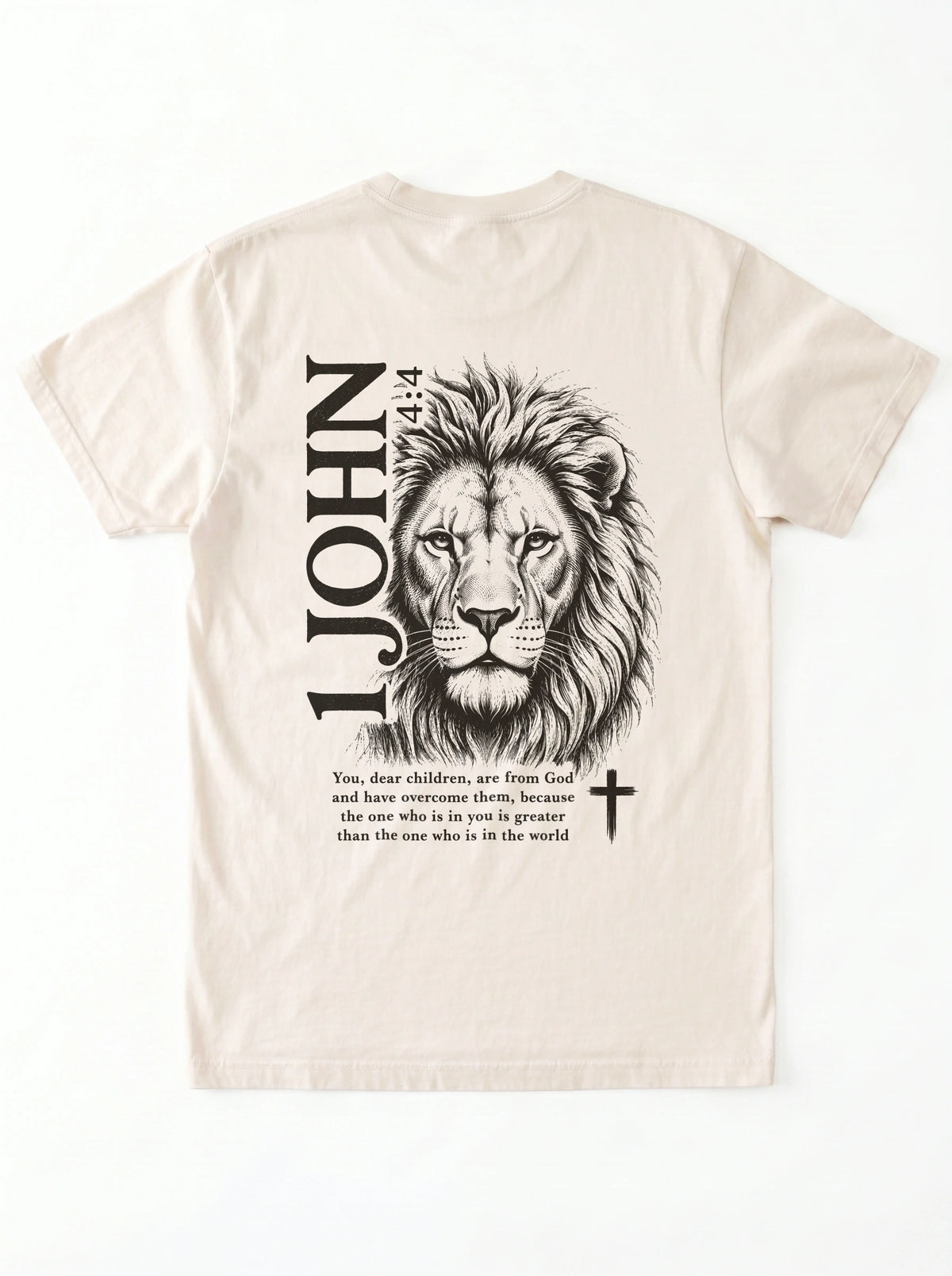 Cream T-shirt laid flat with black “1 John 4:4” text and a cross printed on the chest.