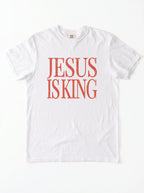 White T-shirt laid flat with distressed orange text reading “Jesus Is King.”