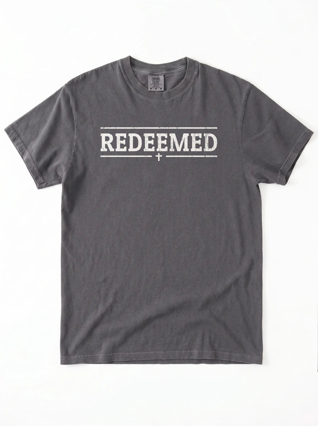 A dark gray crewneck t-shirt with 'REDEEMED' printed in distressed white block letters across the chest, flanked by two horizontal lines and a small cross below, shown flat on a white background.