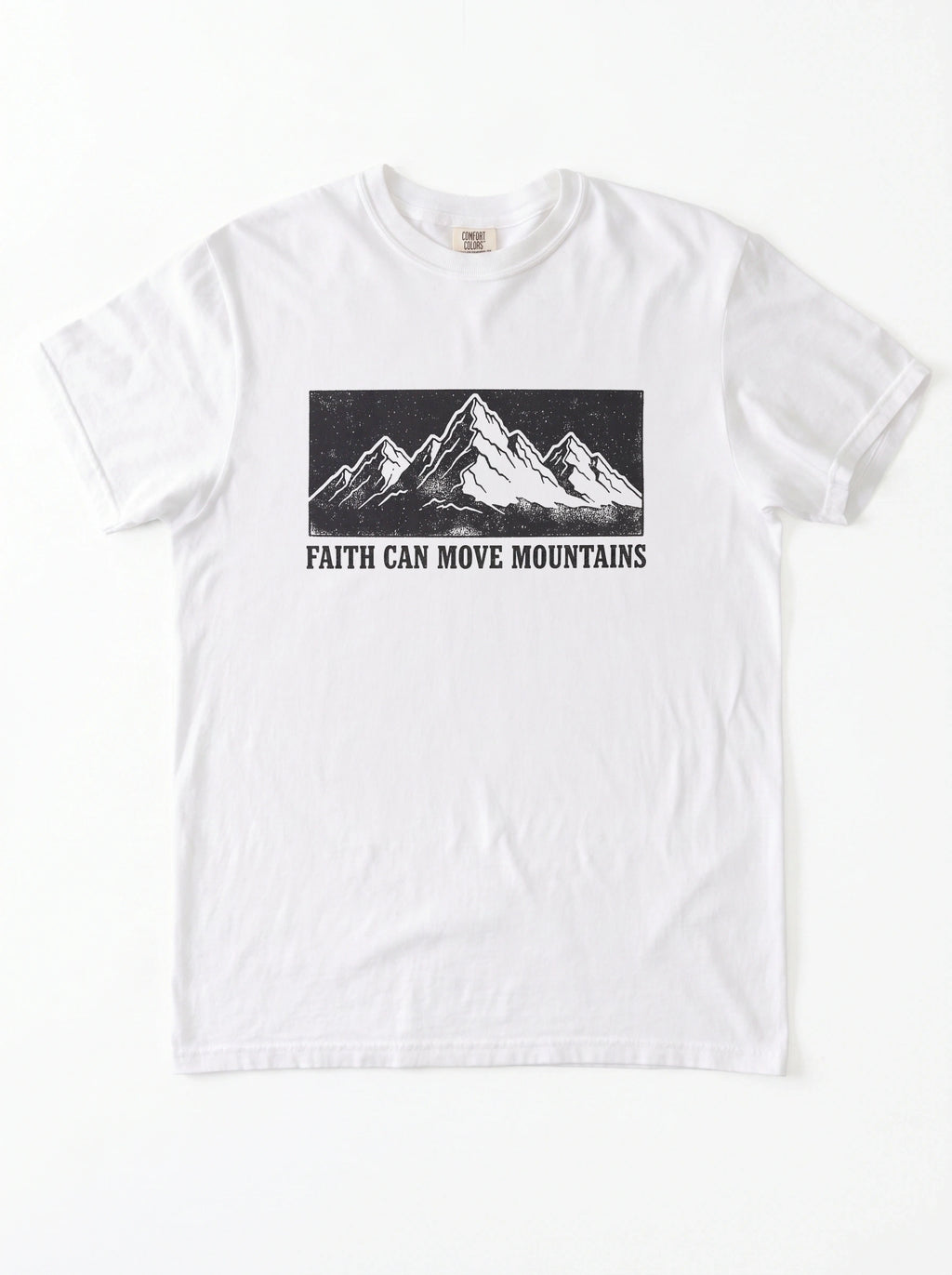 A white short-sleeve crewneck t-shirt featuring a black graphic of a mountain range and the text 'FAITH CAN MOVE MOUNTAINS' printed on the chest.