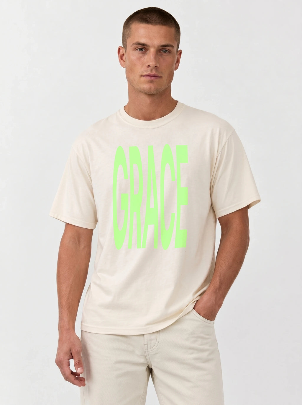 Person wearing a cream T-shirt with large neon green text reading “GRACE.”