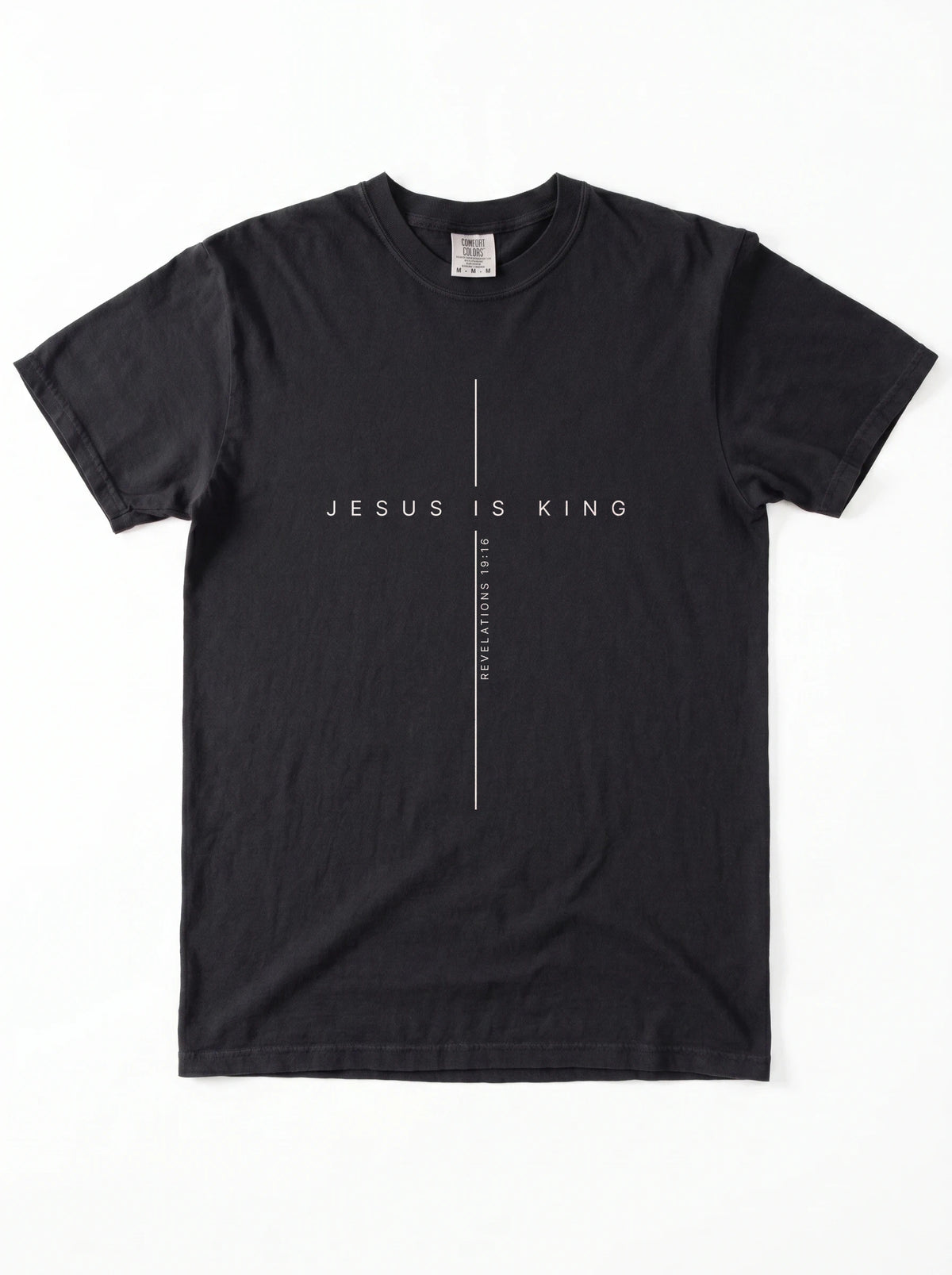 Black T-shirt laid flat with a minimalist cross design and the text “Jesus Is King” and “Revelations 19:16.”