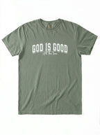 An olive green short-sleeve t-shirt with 'GOD IS GOOD All The Time' printed in white across the chest, displayed flat against a white background.