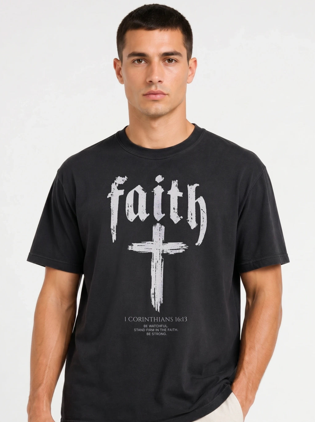 Person wearing a black T-shirt reading “faith” above a cross and “1 Corinthians 16:13 — Be watchful. Stand firm in the faith. Be strong.”