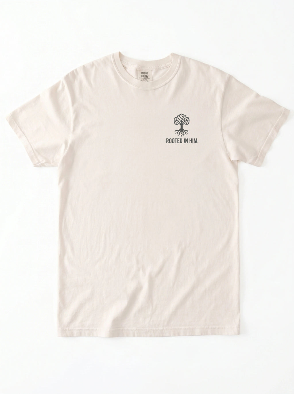 A light cream-colored short-sleeve t-shirt with a small black graphic of a tree and the text 'ROOTED IN HIM.' printed on the left chest, displayed flat against a white background.