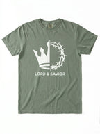 An olive green short-sleeve t-shirt with a white graphic on the front showing a split crown of thorns and cross design with the text 'LORD & SAVIOR' underneath, displayed flat against a white background.