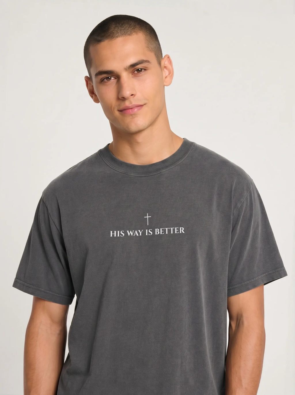 Person wearing a charcoal T-shirt with a small cross above the text “His Way Is Better.”