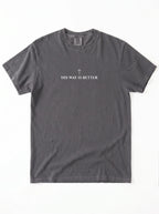 Charcoal T-shirt laid flat with a small cross above the text “His Way Is Better.”