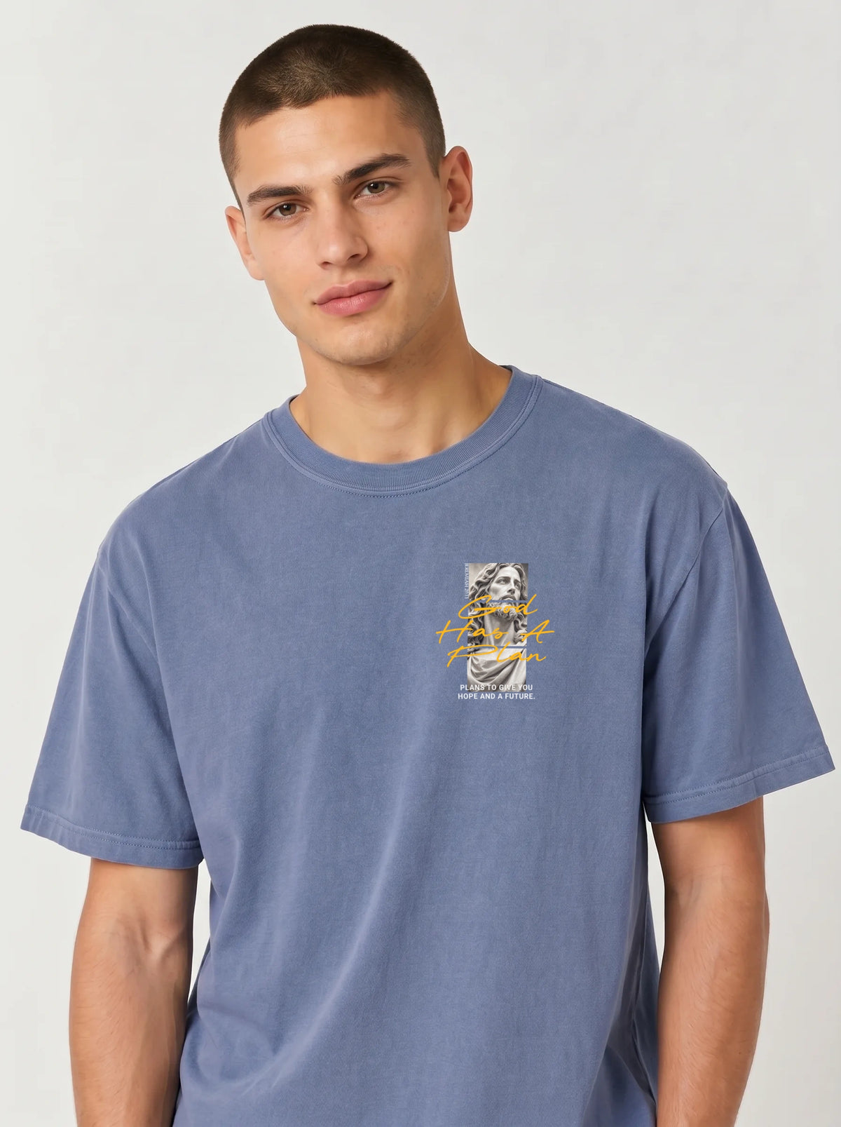 Person wearing a faded blue T-shirt with a statue graphic and the text “God Has A Plan” and “Plans to give you hope and a future.”