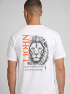 Person wearing a white T-shirt with a lion illustration, orange “1 John 4:4” and cross, and the verse “You, dear children, are from God and have overcome them, because the one who is in you is greater than the one who is in the world.”
