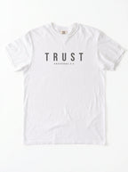 A white short-sleeve crewneck t-shirt with the word 'TRUST' printed in dark gray block letters on the chest, with 'PROVERBS 3:5' printed underneath in smaller text.