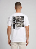 Person shown from behind wearing a white T-shirt with a grayscale Jesus graphic, vertical “Rooted in Christ” text, and Colossians 2:7.
