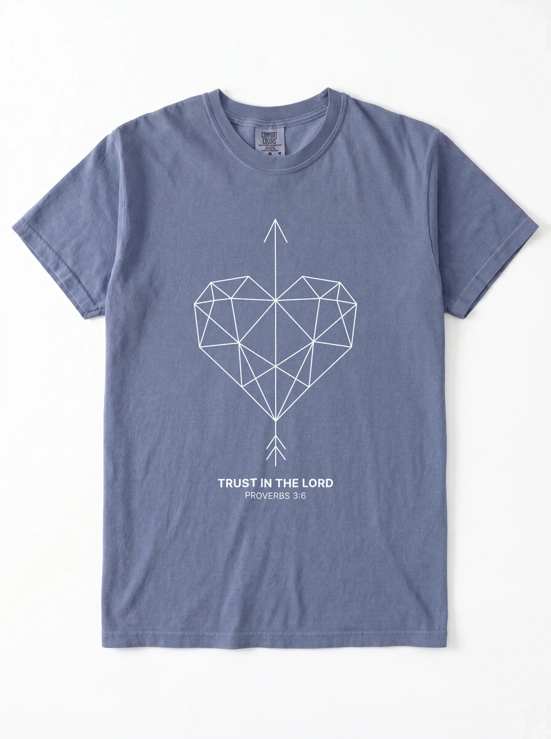 A slate blue crewneck t-shirt with a geometric heart pierced by an upward-pointing arrow, paired with the verse Proverbs 3:6: "Trust in the Lord." printed on the chest, displayed flat against a white background.