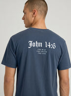 A man wearing a navy blue t-shirt, viewed from the back. The shirt features a white gothic-style print reading 'John 14:6' with the phrases 'THE WAY', 'THE TRUTH', and 'THE LIFE' printed underneath.