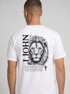 Person wearing a white T-shirt with a black lion illustration, cross, “1 John 4:4,” and the verse text, “You, dear children, are from God and have overcome them, because the one who is in you is greater than the one who is in the world.”