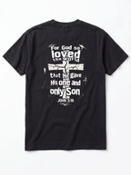 A black short-sleeve t-shirt shown from the back, featuring a distressed white graphic print with a cross and the Bible verse John 3:16.