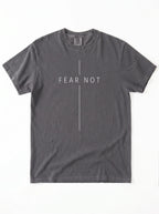 A dark gray crewneck t-shirt with 'FEAR NOT' printed in white across the chest, divided by a vertical line, on a plain white background.