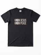 A black short-sleeve crewneck t-shirt with the text 'KNOW JESUS KNOW PEACE' printed in a distressed beige font across the chest, displayed flat against a white background.