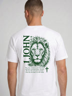 Person wearing a white T-shirt with a green lion illustration, cross, “1 John 4:4,” and the verse text, “You, dear children, are from God and have overcome them, because the one who is in you is greater than the one who is in the world.”