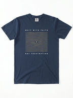 A navy blue short-sleeve t-shirt with a graphic on the front featuring the text 'WAIT WITH FAITH' and 'NOT FRUSTRATION' in white, surrounding a wavy gold grid pattern with a small blue eye in the center.