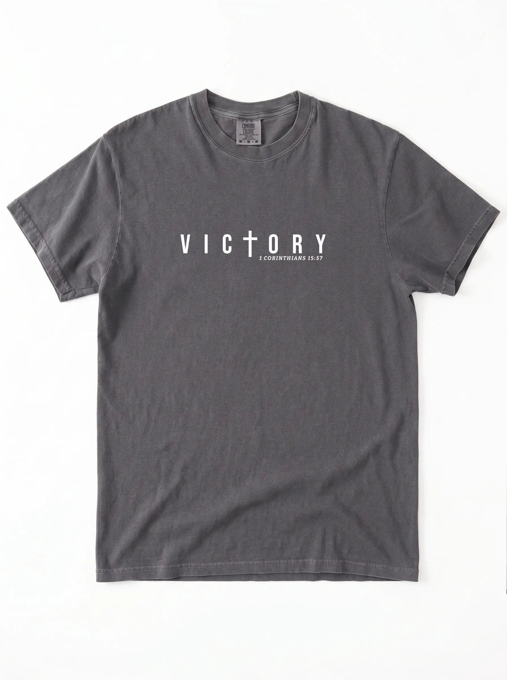 Flat lay of charcoal Comfort Colors 1717 Victory t-shirt with cross graphic and 1 Corinthians 15:57