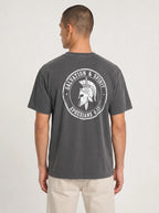 A man viewed from the back wearing a dark gray t-shirt with a white circular graphic on the back featuring a gladiator helmet and the text 'SALVATION & SPIRIT EPHESIANS 6:17'.
