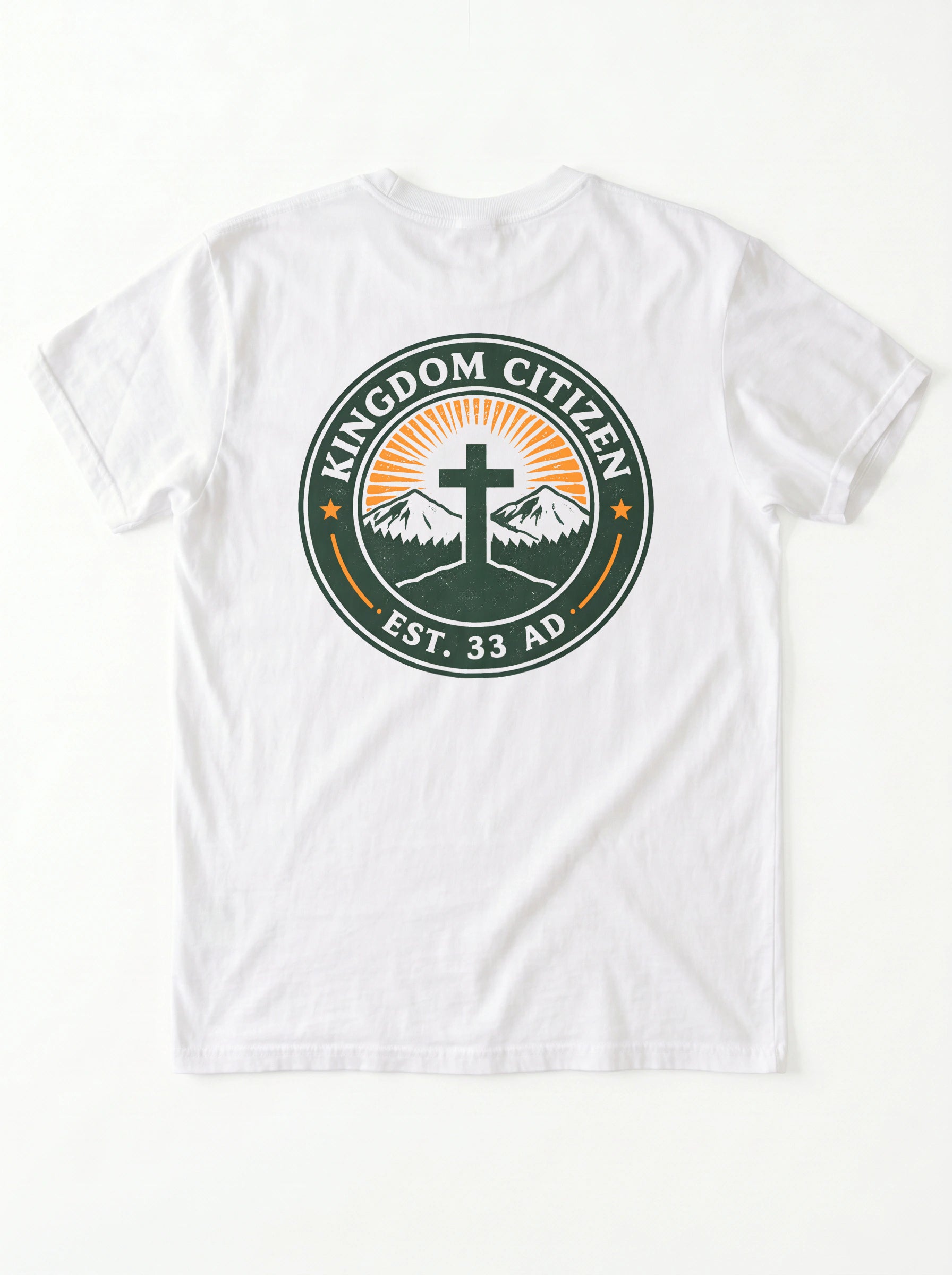 A white short-sleeve t-shirt laid flat against a white background, featuring a circular graphic on the chest with the text 'KINGDOM CITIZEN' and 'EST. 33 AD' surrounding a cross, mountains, and sunburst.