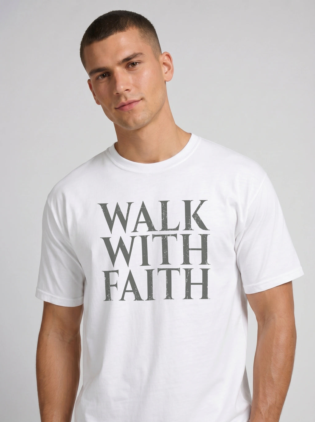 Person wearing a white T-shirt with distressed gray text reading “Walk With Faith.”