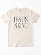 Flat lay of ivory Comfort Colors 1717 Jesus Is King graphic tee