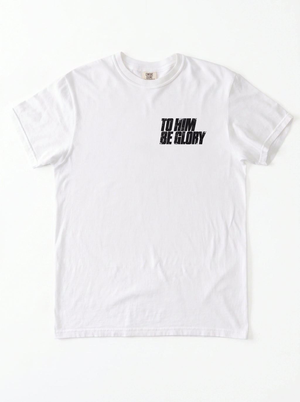 White T-shirt laid flat with a distressed chest print reading “To Him Be Glory.”