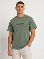 Person wearing a muted green T-shirt with the black text “It’s Always God.”