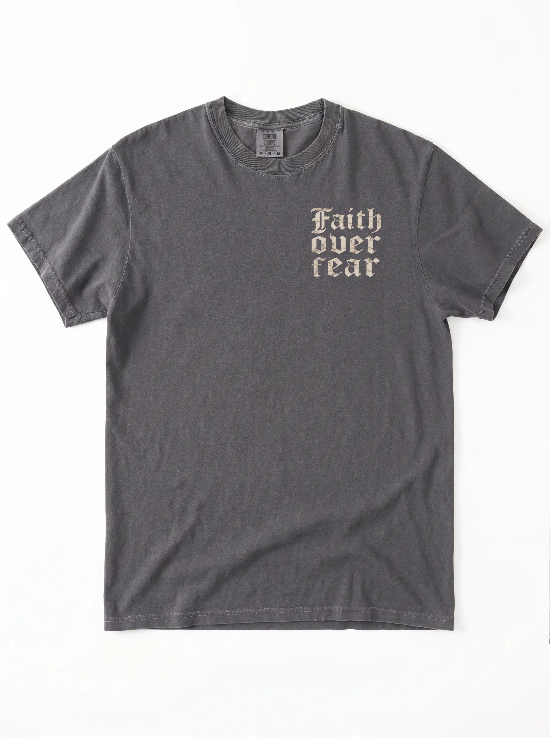 A dark gray crewneck t-shirt with the words 'Faith over fear' printed in a beige gothic font on the left chest, displayed flat against a white background.