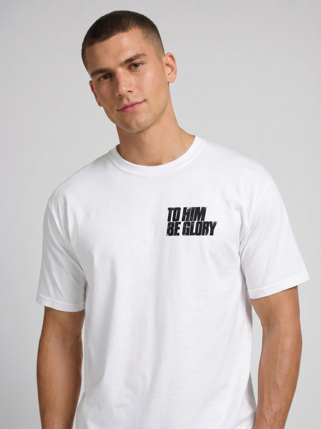 Person wearing a white T-shirt with a distressed chest print reading “To Him Be Glory.”