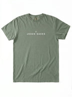 An olive green short-sleeve t-shirt with 'JESUS SAVES' and a small cross printed in white on the chest, laid flat against a white background.