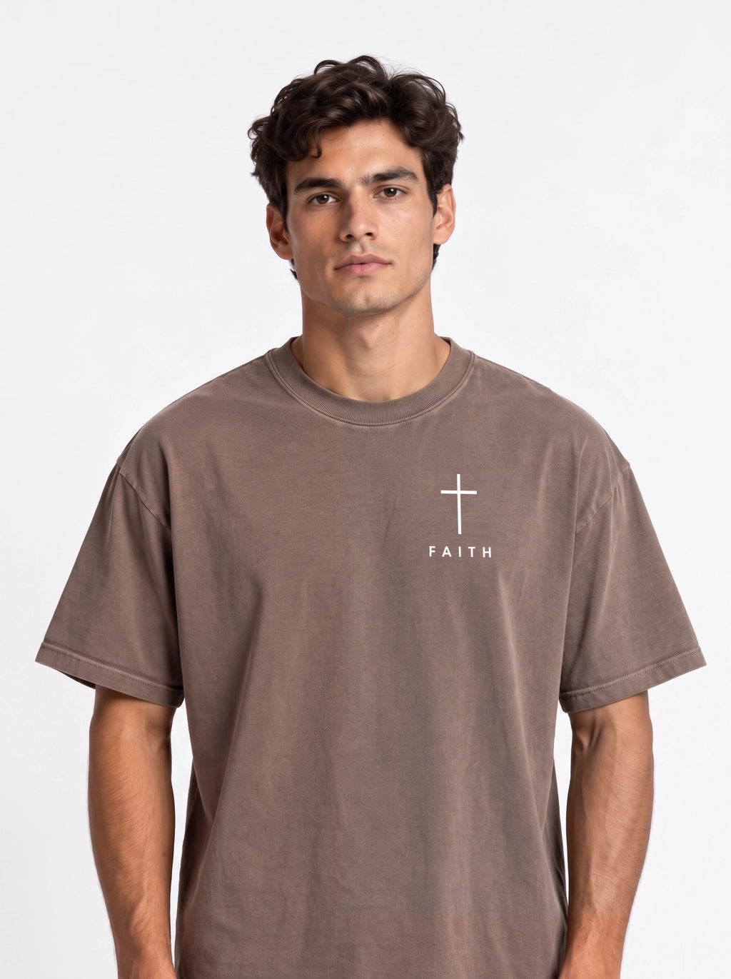 Person wearing a faded brown T-shirt with a white cross and “FAITH” printed on the chest.