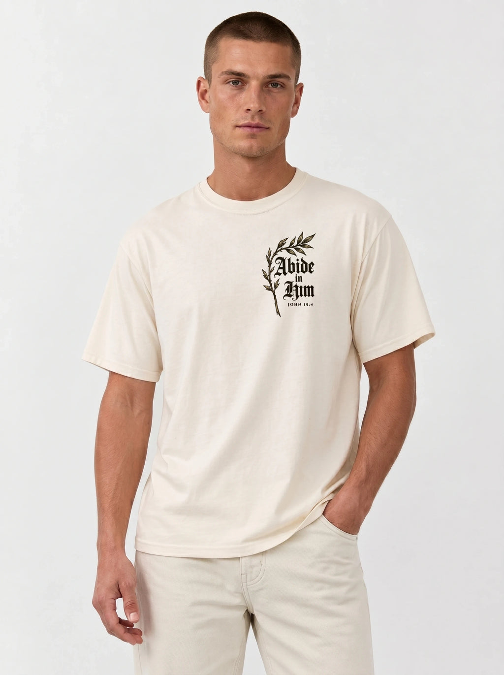 Cream T-shirt with a leafy chest graphic reading “Abide in Him” and “John 15:4.”