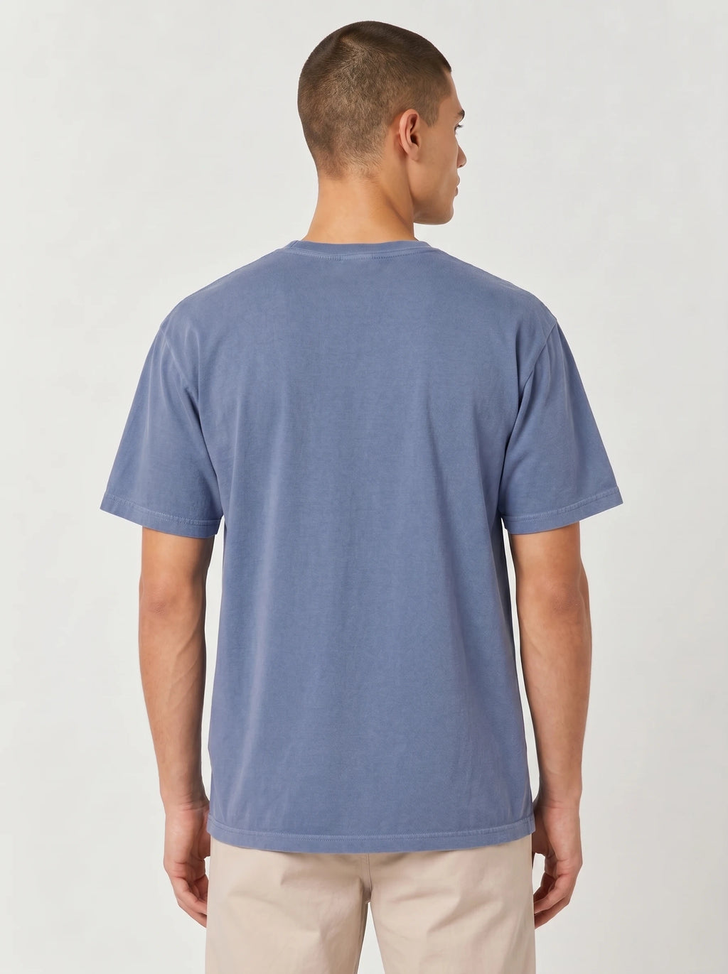 A man wearing a faded blue crewneck t-shirt viewed from the back.